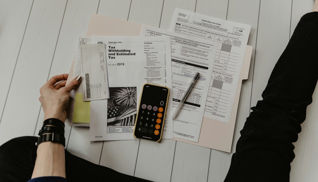 Person reviewing a financial document beside a calculator
